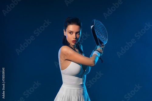 Padel tennis player with racket on tournament. Girl athlete with paddle racket on court at open tour. Neon colors. Sport concept. Download a high quality photo for design of a sports app.