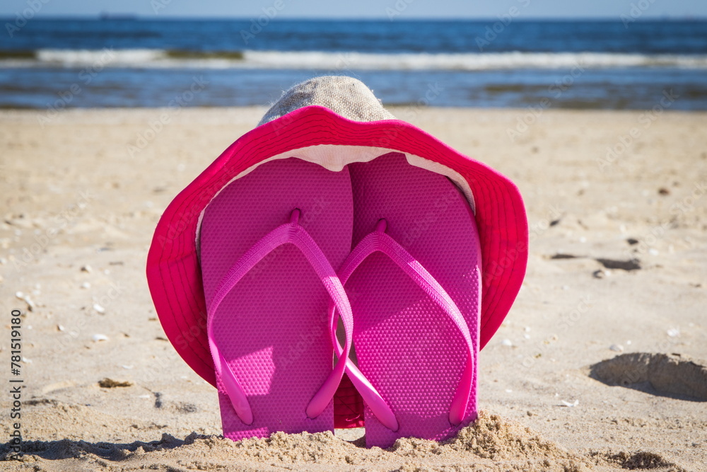 Flip flop and straw hat on beach. Accessories for relax on sand. Summer vacation Flip flop and straw hat on beach. Accessories for relax on sand. Summer vacation