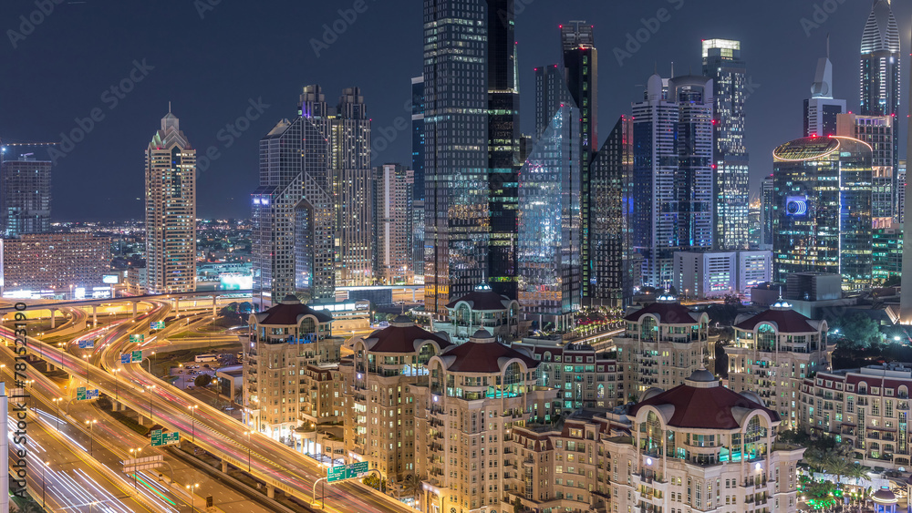 Aerial view of illuminated skyscrapers and road junction in Dubai timelapse