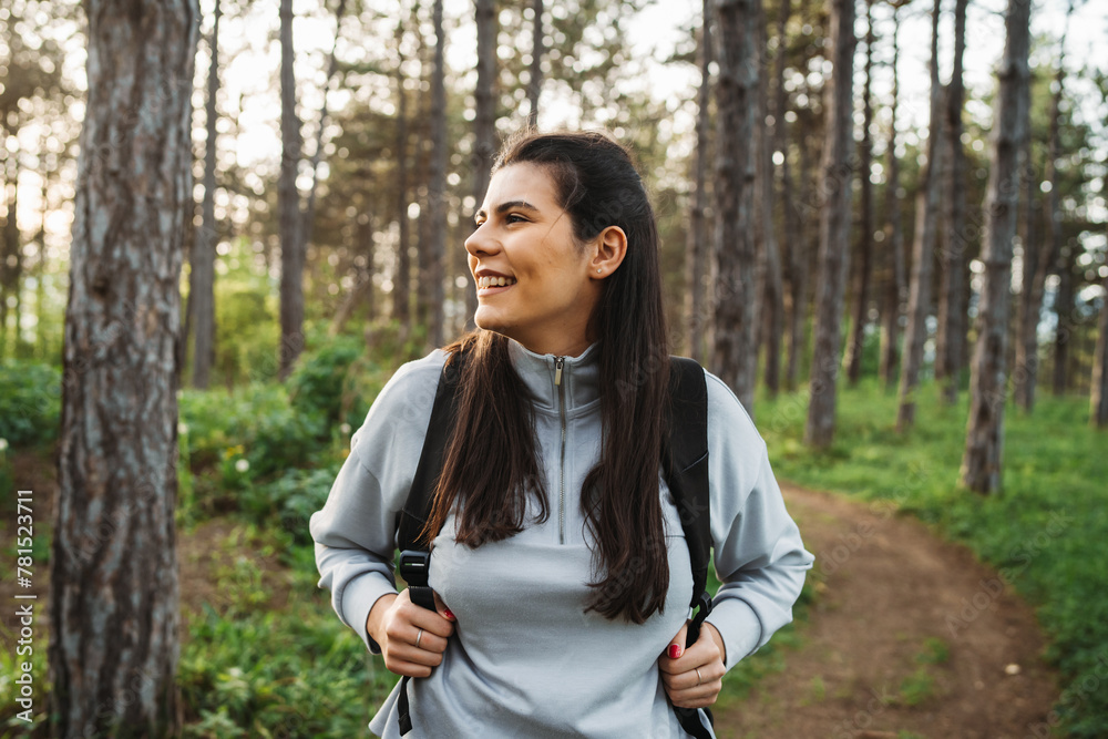 One young caucasian woman is hiking through the forest and looking for the way One young caucasian woman is hiking through the forest and looking for the way