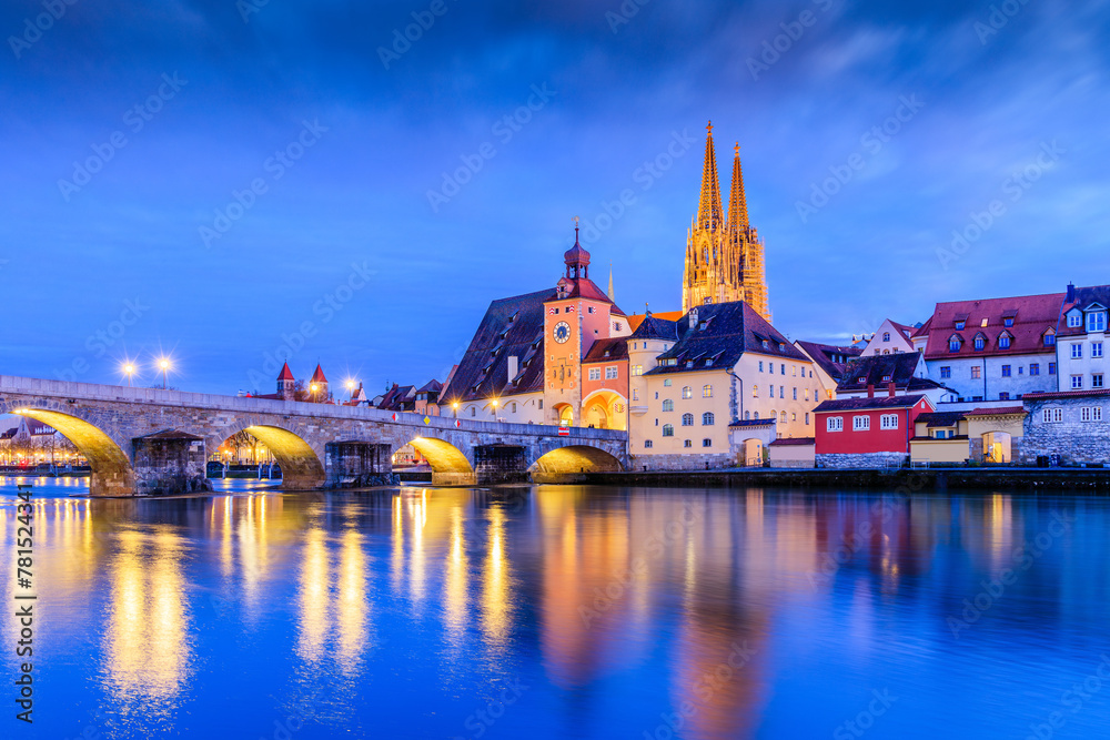 Regensburg, Bavaria, Germany. Cathedral of St. Peter and the Stone Bridge over the Danube river at night.