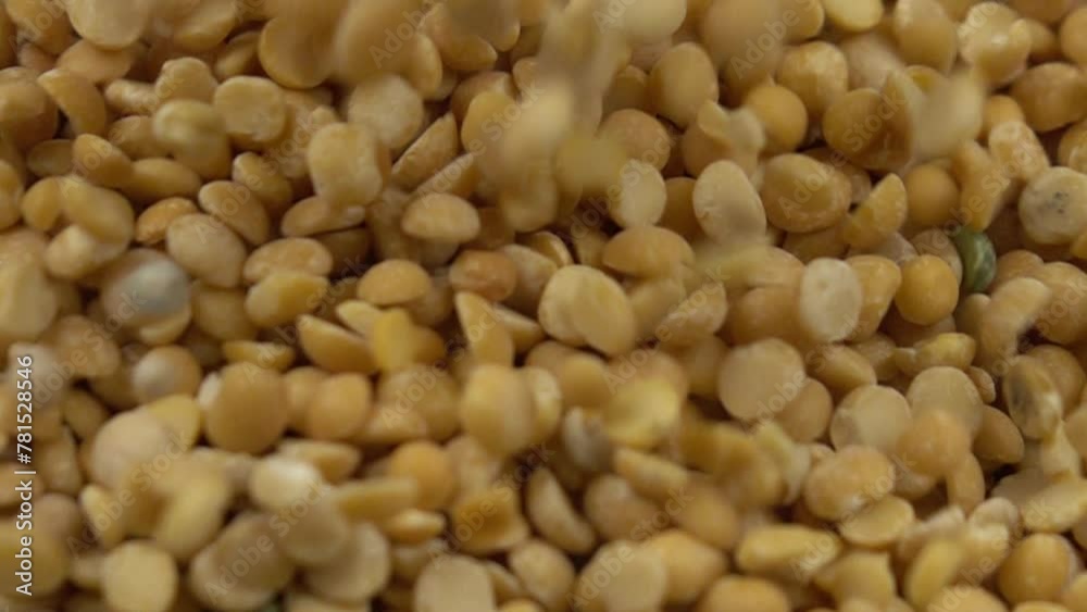 Broken dried yellow peas are poured on a heap of the yellow peas, slow motion Broken dried yellow peas are poured on a heap of the yellow peas, slow motion