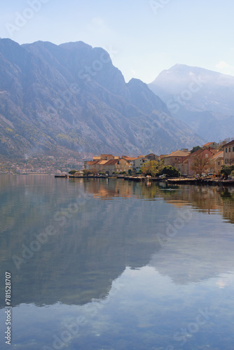 Beautiful Mediterranean landscape in spring. Montenegro, Adriatic Sea. View of coast of Kotor Bay and Prcanj town. Mountains and small town reflected in water