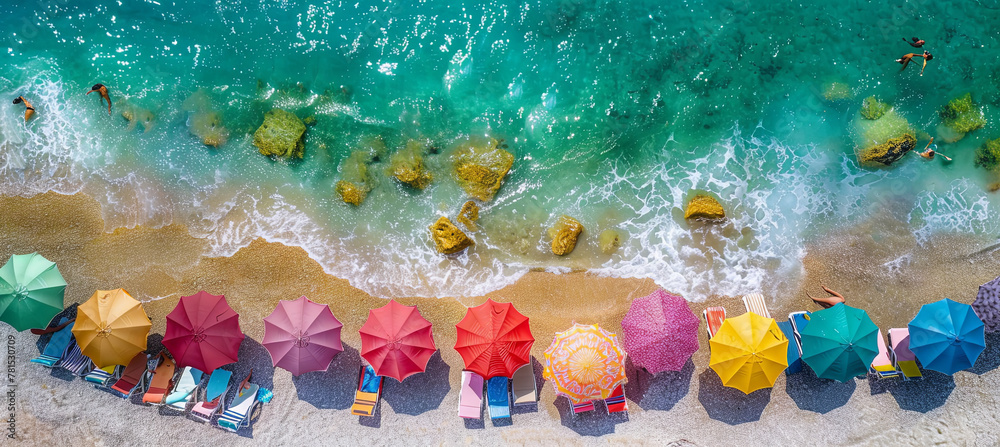 Fototapeta premium Aerial view of ocean shore with sun umbrellas, concept of summer holidays