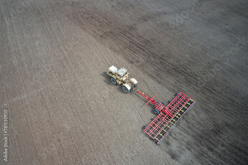 Pre-sowing soil preparation. Tractor with trailed combined tillage machine working on the field. Drone footage.
