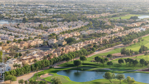 Photography Aerial view to villas and houses with Golf course with green lawn and lakes time