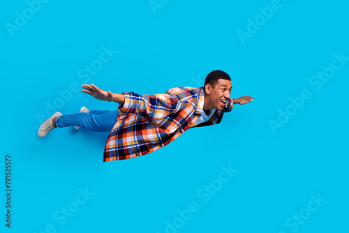 Full size photo of nice young man flying empty space wear shirt isolated on blue color background