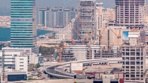 Dubai media city skyscrapers and construction site on palm jumeirah timelapse, Dubai, United Arab Emirates photo
