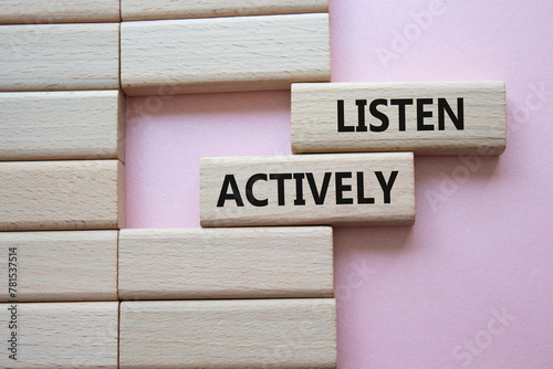Listen actively symbol. Wooden blocks with words Listen actively. Beautiful pink background. Business and Active listening concept. Copy space.