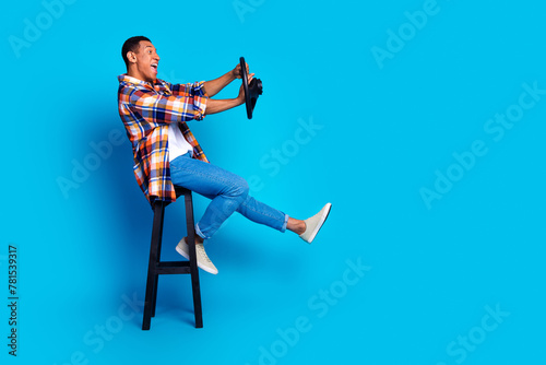 Full length profile photo of nice young man beep wheel empty space wear shirt isolated on blue color background photo