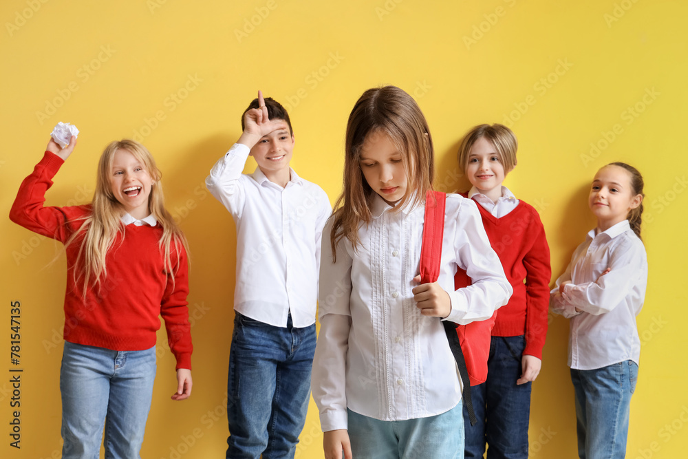 Obraz premium Bullied little girl and her classmates on yellow background