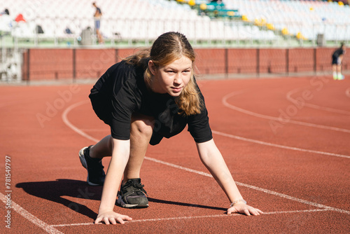 Athlete teenager preparing before jogging running, stretching legs before workout training outdoors on stadium in the morning.