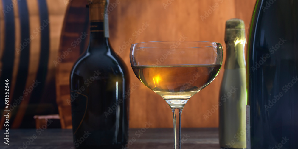 A beautiful semicircular glass with strong alcohol on a background of oak barrels and bottles with elite alcohol
