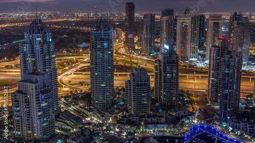 Dubai Marina skyscrapers and jumeirah lake towers view from the top aerial night to day timelapse in the United Arab Emirates.