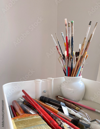Paint brushes, spatula and artist material in a studio. Art supplies. Creative tools in a mobile cart.