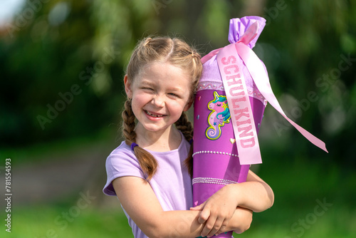 blondes glückliches sechsjähriges Mädchen mit Schultüte und Schulrucksack, erstklässlerin, sonniger tag, schulanfang