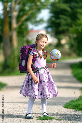 blondes glückliches sechsjähriges Mädchen mit Schultüte und Schulrucksack, erstklässlerin, sonniger tag, schulanfang, ganz körper