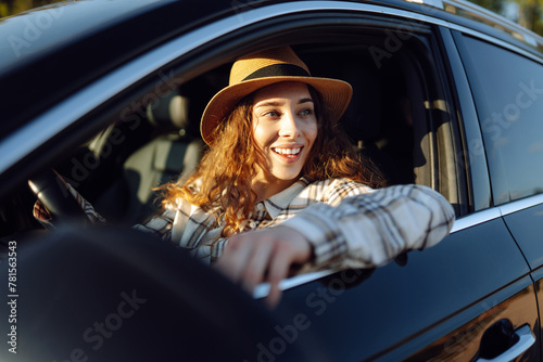 Female driver. Portrait of young woman is driving a car. Automobile travel. Car sharing.