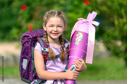 blondes glückliches sechsjähriges Mädchen mit Schultüte und Schulrucksack, erstklässlerin, sonniger tag, schulanfang