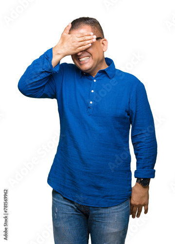 Middle age arab man wearing glasses over isolated background smiling and laughing with hand on face covering eyes for surprise. Blind concept.