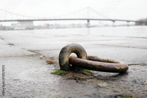 Boat mooring ring on the quay with the bridge in the background.