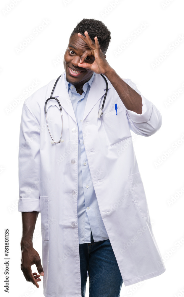 Young african american man wearing doctor coat with happy face smiling doing ok sign with hand on eye looking through fingers Young african american man wearing doctor coat with happy face smiling doing ok sign with hand on eye looking through fingers