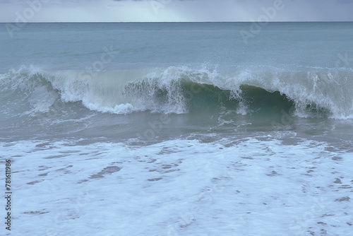 Waves breaking on the shore on small pebble beach