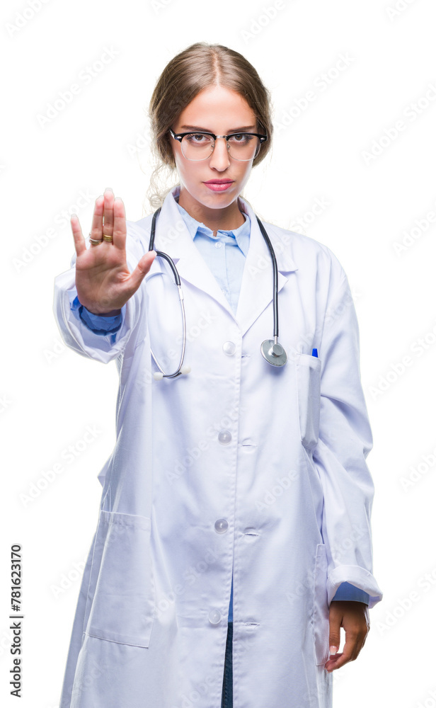 Beautiful young blonde doctor woman wearing medical uniform over isolated background doing stop sing with palm of the hand. Warning expression with negative and serious gesture on the face.