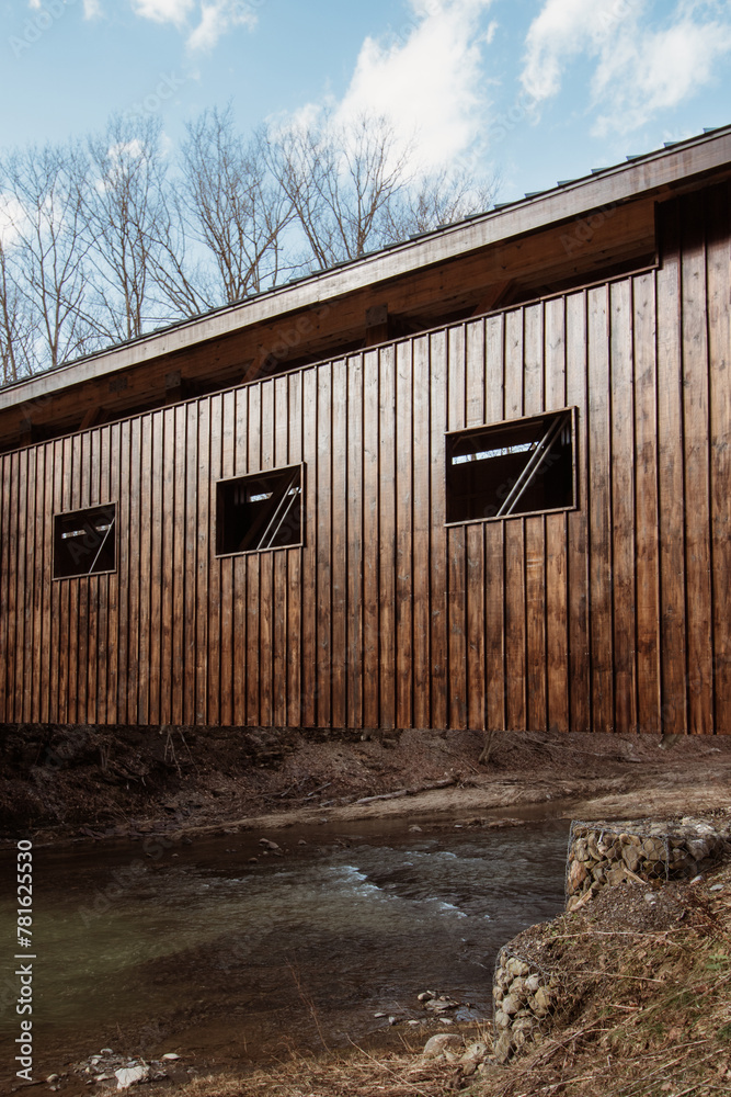 Side of a covered wooden bridge over a flowing creek in New York State, USA Side of a covered wooden bridge over a flowing creek in New York State, USA