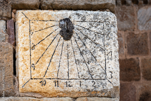 Ancient Sundial on Stone Wall. Capture the essence of history with this image of an ancient sundial embedded in a stone wall. The weathered carvings tell tales of time and tradition.