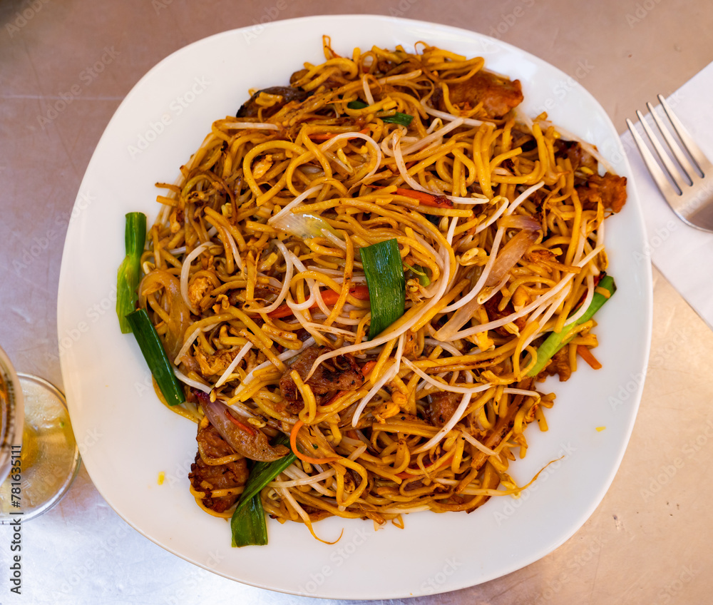 Popular Chinese dish chow mein of fried noodles with beef pieces and vegetables in spicy sauce