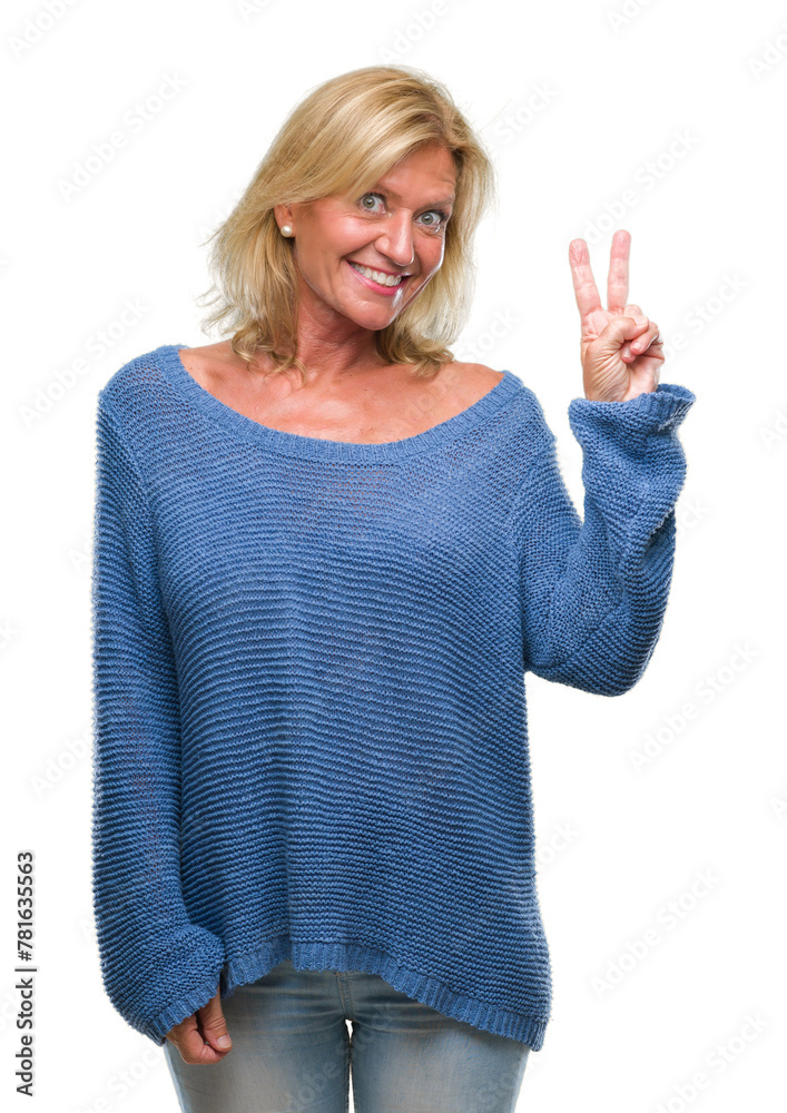 Middle age blonde woman wearing winter sweater over isolated background smiling with happy face winking at the camera doing victory sign. Number two. Middle age blonde woman wearing winter sweater over isolated background smiling with happy face winking at the camera doing victory sign. Number two.
