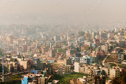View of Kathmandu capital of Nepal from mountain through urban haze with lot of low rise buildings, cityscape creating an ethereal atmosphere in mountain air, Kathmandu air pollution © TRAVELARIUM