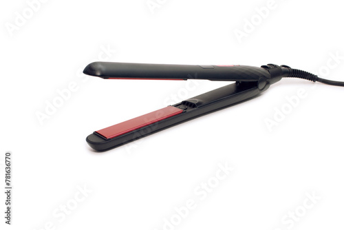 Black electronic hair straightener isolated on white background close-up. Hair straightener with ceramic plates for styling hair. The concept of styling hair at home