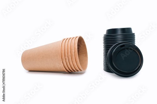 A stack of disposable coffee cups and black plastic lids for them on a white background. Empty cardboard cups that can be recycled. Disposable paper cups photo