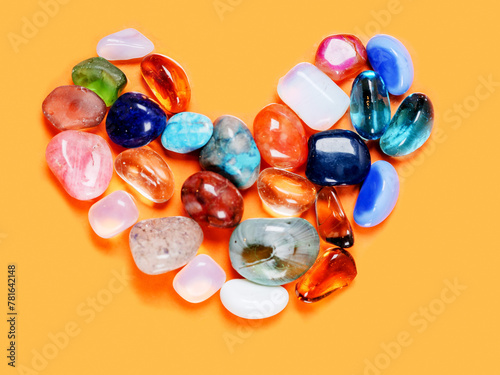 Heart made from colorful rocks on orange background. Handmade love expression.