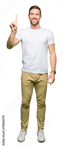 Handsome man wearing casual white t-shirt showing and pointing up with finger number one while smiling confident and happy.