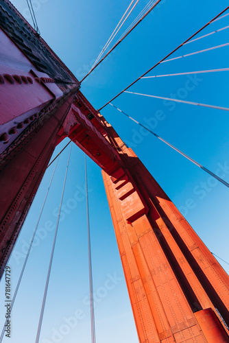 Fototapeta Naklejka Na Ścianę i Meble -  Majestic architecture of the Golden Gate Bridge captured from the roadway, clear blue sky in the background