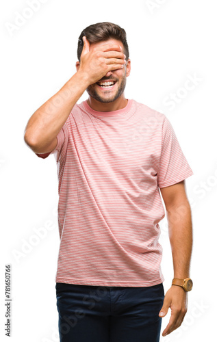Young handsome man over isolated background smiling and laughing with hand on face covering eyes for surprise. Blind concept.