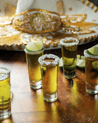 Shots of tequila with salt and lemon on a wooden table. Festive background cinco de mayo and mexican independence day.