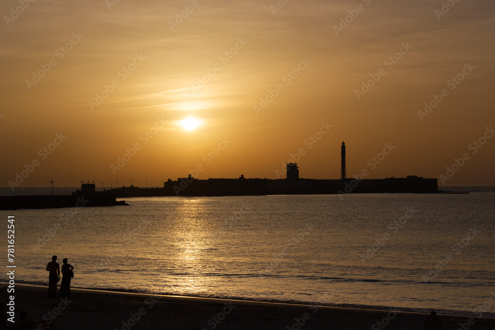 Couple walking at sunset at La Caleta beach, Cadiz, Andalusia, Spain. Couple walking at sunset at La Caleta beach, Cadiz, Andalusia, Spain.