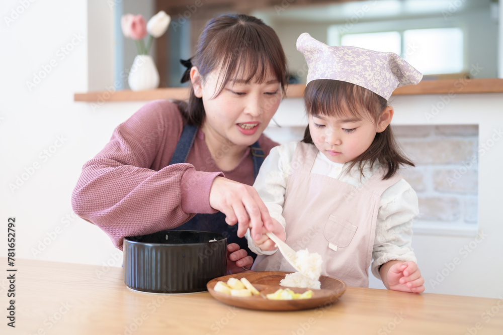 ご飯を盛り付ける親子 女の子とお母さん ご飯を盛り付ける親子 女の子とお母さん