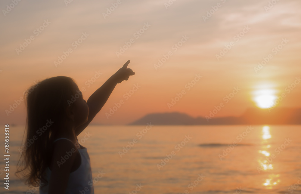 Silhouette of a child at sunset on the sea