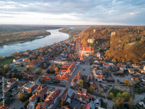 View of the historic buildings of Kazimierz Dolny on the Vistula River with the market square and parish church at sunset 