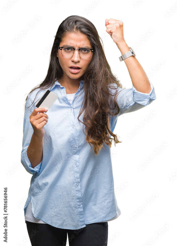 Young arab woman holding credit card over isolated background annoyed and frustrated shouting with anger, crazy and yelling with raised hand, anger concept Young arab woman holding credit card over isolated background annoyed and frustrated shouting with anger, crazy and yelling with raised hand, anger concept