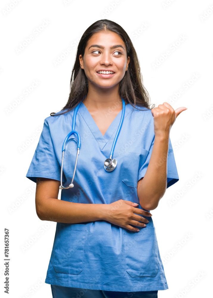 Young arab doctor surgeon woman over isolated background smiling with happy face looking and pointing to the side with thumb up. Young arab doctor surgeon woman over isolated background smiling with happy face looking and pointing to the side with thumb up.