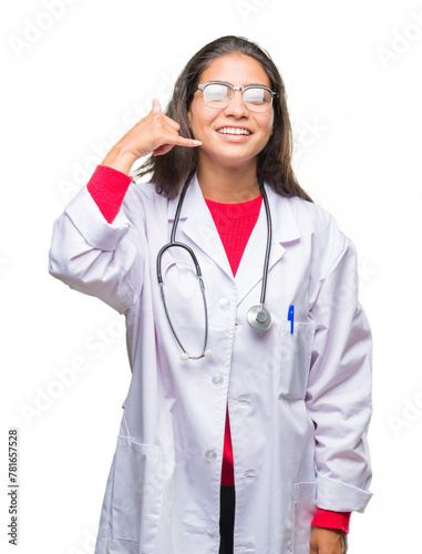 Young arab doctor woman over isolated background smiling doing phone gesture with hand and fingers like talking on the telephone. Communicating concepts.