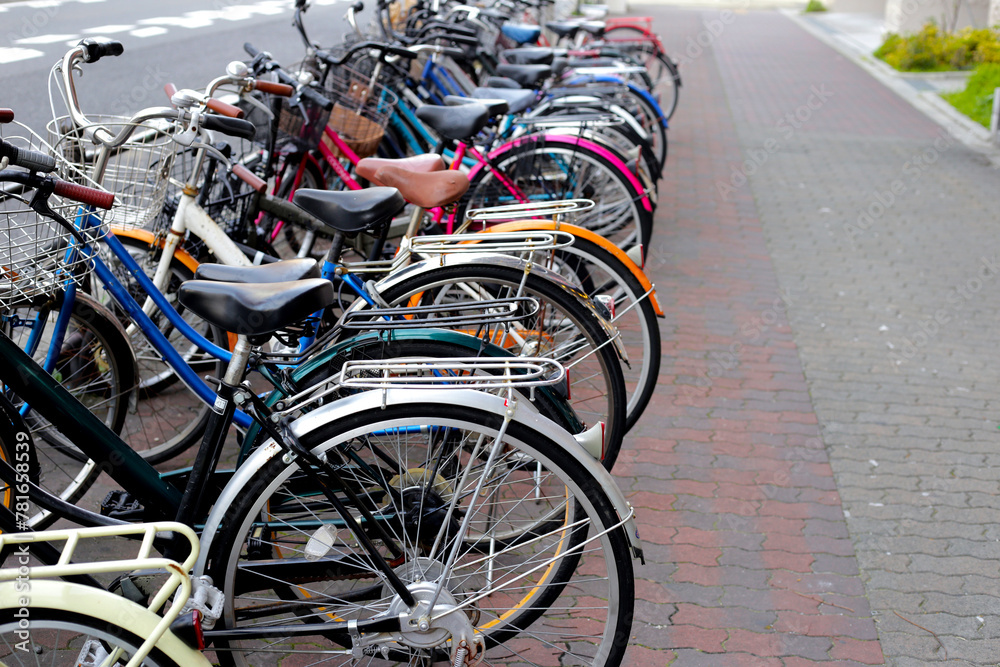 A group of bicycles lined up in a row on the sidewalk.