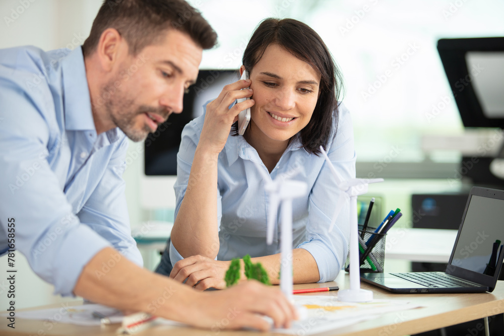 portrait of male architect and woman discussing plan - obrazy, fototapety, plakaty 