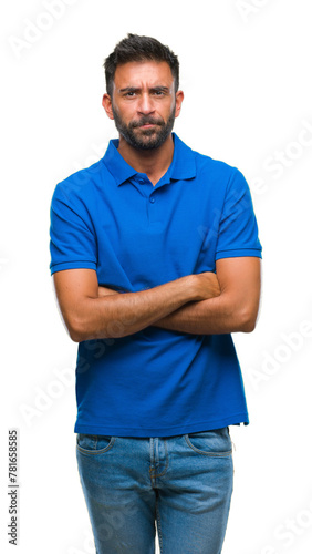 Adult hispanic man over isolated background skeptic and nervous, disapproving expression on face with crossed arms. Negative person.